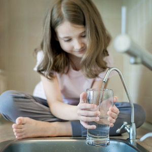 girl filling glass with tap water